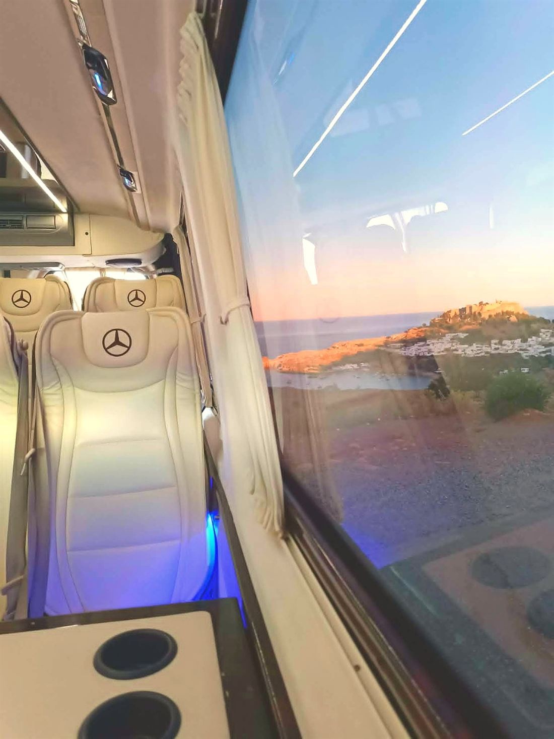 View of Lindos Acropolis at sunset through the window of the Mercedes-Benz VIP minibus